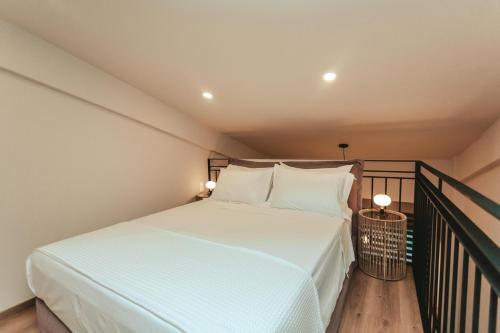 a bedroom with a bed with white sheets and pillows at Amoessa Boutique - Adults Only in Polykhrono
