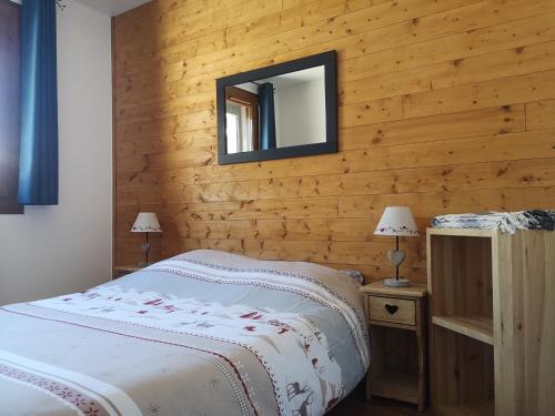 um quarto com uma cama e um espelho na parede em La Souloise em Le Dévoluy
