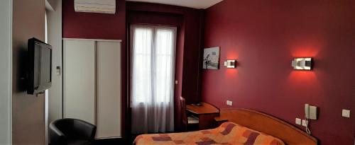 a red room with a bed and a window at Hotel de La Paix in Oloron-Sainte-Marie