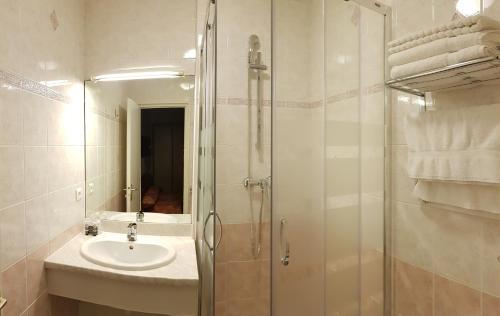 a bathroom with a shower and a sink at Hotel de La Paix in Oloron-Sainte-Marie