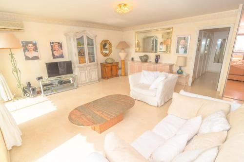 - un salon avec deux canapés blancs et une télévision dans l'établissement Cannes Stunning sea and old town view for our full comfort 3 BR with balcony by Olam Properties, à Cannes