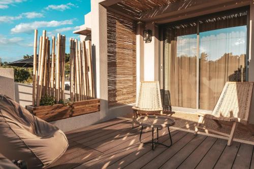 a patio with two chairs and a table on a deck at Amoessa Boutique - Adults Only in Polykhrono