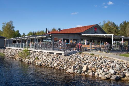a building with a bunch of rocks next to a river at Lakelodge in Karlskoga