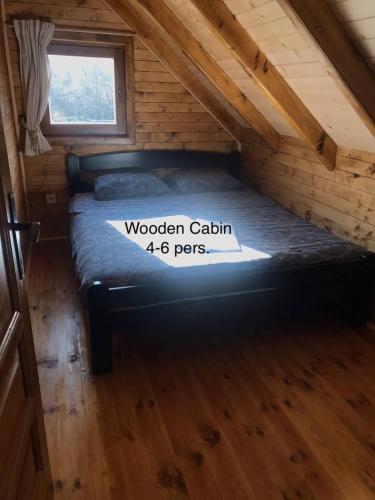a bed in a wooden cabin with a sign on it at Camp Lipovo in Kolašin