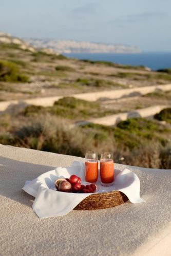 a plate of fruit and two glasses of orange juice at Cap Rocat, a Small Luxury Hotel of the World in Cala Blava