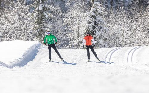 two people on skis in the snow at BOUTIQUEHOTEL das edelweiss in Schoppernau