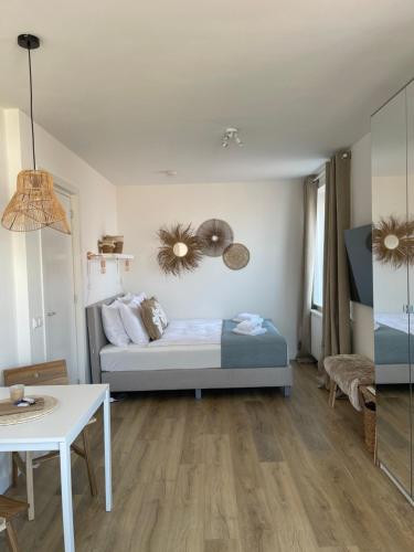 Una habitación con una cama y una mesa dentro. en Pure Studio, en Zandvoort