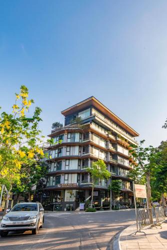 a car parked in front of a tall building at 22Land Moon West Lake in Hanoi