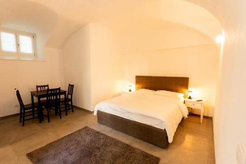 a bedroom with a bed and a table and chairs at ALPENCITY SUITES in Trento