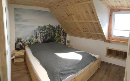 a bedroom with a bed with a painting on the wall at Ferienwohnung Julia in Hohnstein