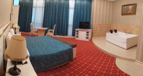 a hotel room with a bed and a bath tub at Spring Hotel in Novxanı