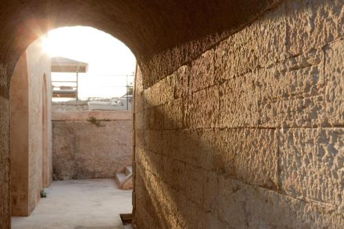 an archway in a brick wall with the sun shining at Cap Rocat, a Small Luxury Hotel of the World in Cala Blava