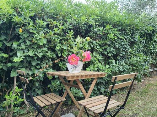 a table with a vase of flowers and two chairs at Villa Martina in Mascalucia