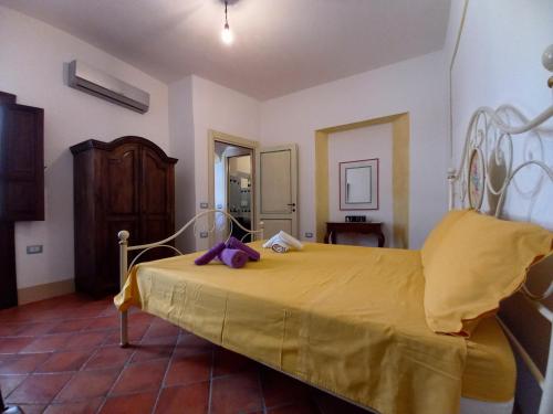 een slaapkamer met een bed met een gele deken bij Domos Anticas in Galtellì