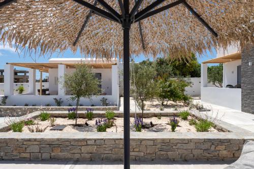 a straw umbrella in front of a building at Drios Luxury Studios in Drios