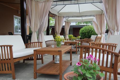 a patio with chairs and tables and an umbrella at Hotel Anchor in Sinemorets