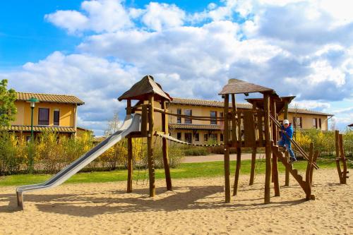 テンプリーンにあるFerienpark Templin direkt neben der Naturthermeの遊び場の滑り台で遊ぶ少年
