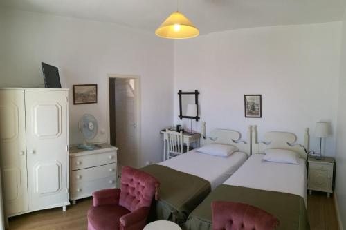 um quarto com uma cama grande e 2 cadeiras em Pensao Residencial Vila Teresinha em Funchal