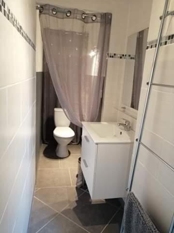a bathroom with a toilet and a shower curtain at Plénitude in Sérignan