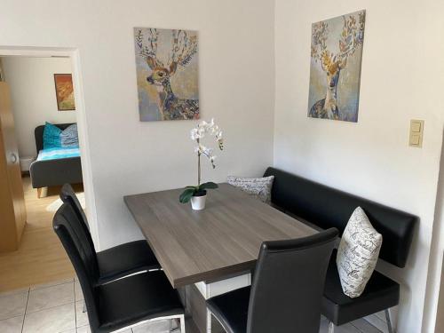 a dining room with a wooden table and black chairs at Apartment Stella in Bad Ischl
