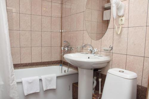 a bathroom with a sink and a toilet and a tub at Moskovskaya Zastava Hotel in Kostroma