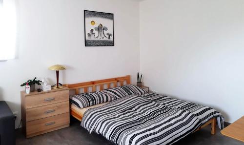 a bedroom with a bed and a dresser at Do zahrady in Liberec
