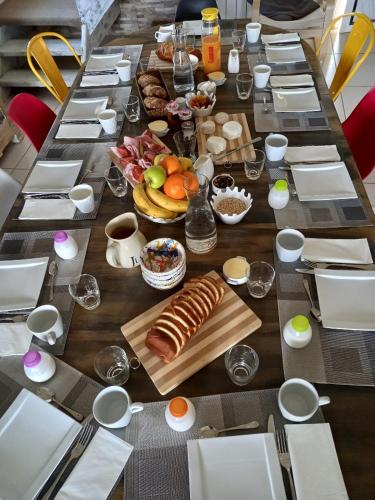 een lange houten tafel met eten erop bij Le Colombier in Ruffey-lès-Beaune