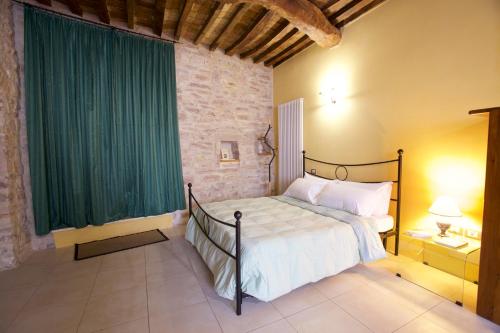 a bedroom with a bed with a green curtain at LE DIMORE ARCANGELO Maria in Assisi