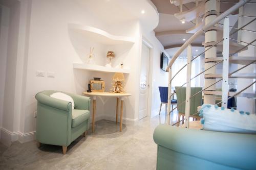 a living room with chairs and a table and stairs at Cavalieri D'Oro Luxury House in Anzio