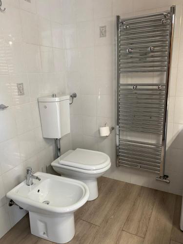 a white bathroom with a toilet and a sink at AGORA' Home in Gardone Riviera