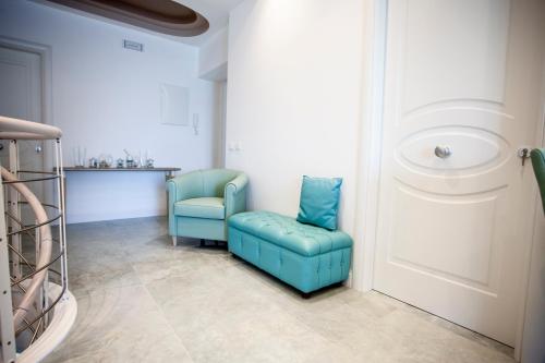 a room with two blue chairs and a door at Cavalieri D'Oro Luxury House in Anzio