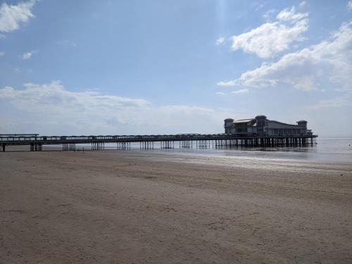 a pier on the beach with a building on it at Parasol Weston Guest House in Weston-super-Mare