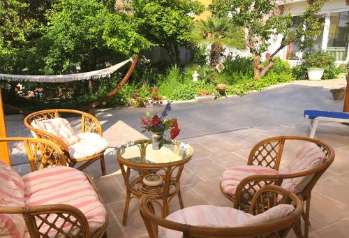 a patio with chairs and a glass table with at B&B IreneMarchese Gluten Free in Taviano