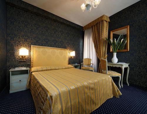 een slaapkamer met een bed met een gele sprei bij Hotel Castello in Venetië