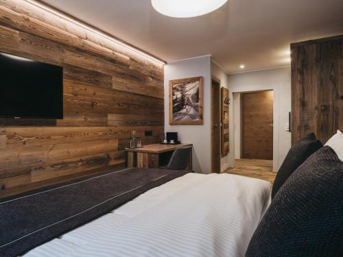 a bedroom with a bed and a flat screen tv at VAYA Post Saalbach inklusive Joker Card in Saalbach Hinterglemm