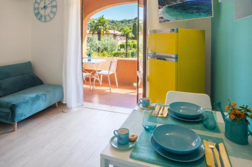 a living room with a table and a yellow refrigerator at Appartamenti LE TRE API in Porto Azzurro