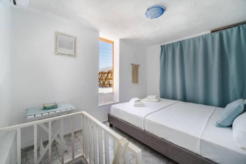 sypialnia z 2 łóżkami i oknem w obiekcie MARIAS'VIEW HOUSE w Akrotiri