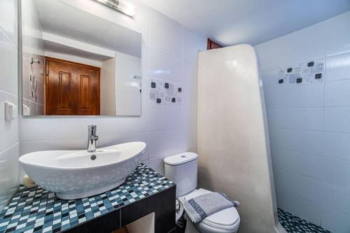 Baño blanco con lavabo y aseo en MARIAS'VIEW HOUSE en Akrotiri