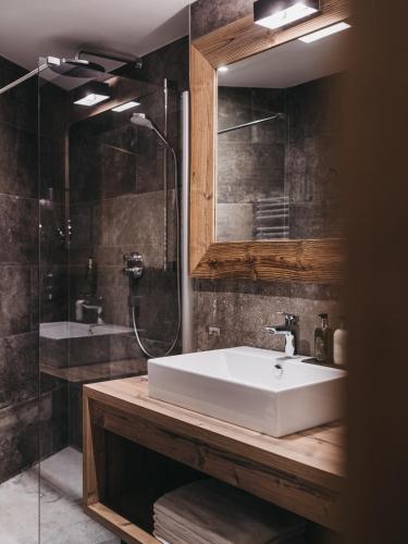 a bathroom with a white sink and a shower at VAYA Post Saalbach inklusive Joker Card in Saalbach Hinterglemm