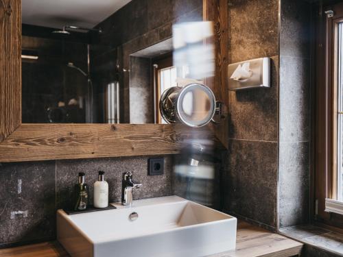 a bathroom with a sink and a mirror at VAYA Post Saalbach inklusive Joker Card in Saalbach Hinterglemm