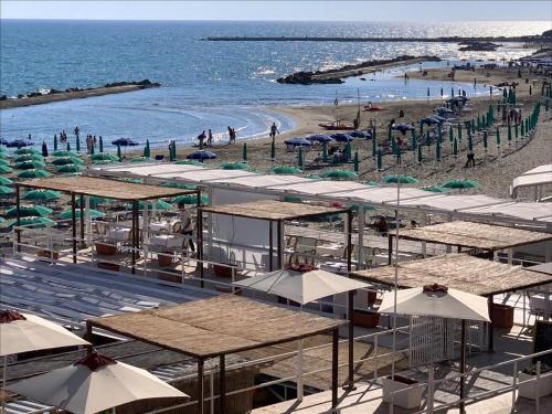 a beach with umbrellas and people on the beach at Cavalieri D'Oro Luxury House in Anzio