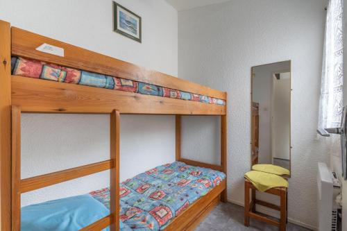 - une chambre avec des lits superposés et une chaise jaune dans l'établissement L'Agate, au Cap d'Agde
