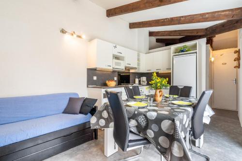 une salle à manger avec une table et un canapé bleu dans l'établissement L'Agate, au Cap d'Agde