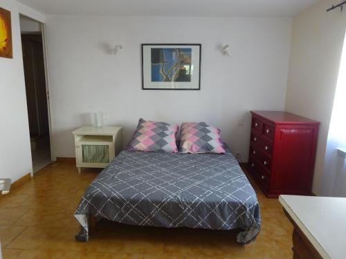 a small bedroom with a bed and a red dresser at Entre mer et lac Salagou in Saint-André-de-Sangonis