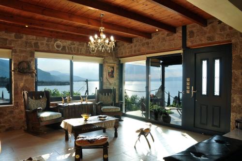 a living room with a chandelier and large windows at Magical view, Villa Asproneri, Kamena Vourla in Kamena Vourla