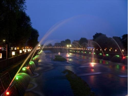 a view of a river at night with lights at Hotel Wing International Chitose in Chitose