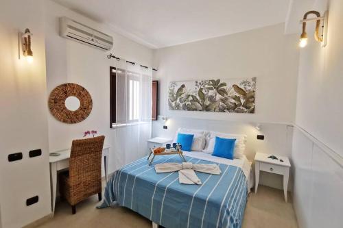 - une chambre avec un lit doté d'oreillers bleus et d'un bureau dans l'établissement Loft Cocorito - 100 metri dalla spiaggia di sabbia bianca e dal mare, à Fontane Bianche