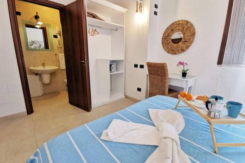 - une chambre avec un lit bleu et une salle de bains dans l'établissement Loft Cocorito - 100 metri dalla spiaggia di sabbia bianca e dal mare, à Fontane Bianche