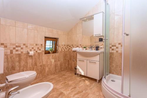 ein Bad mit einem WC, einem Waschbecken und einer Dusche in der Unterkunft Villa Calma with heated pool,jacuzzi, Finnish sauna and 4 bedrooms in Gata