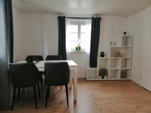 a dining room with a table and chairs and a window at Ferienwohnung Benz in Klingenmünster